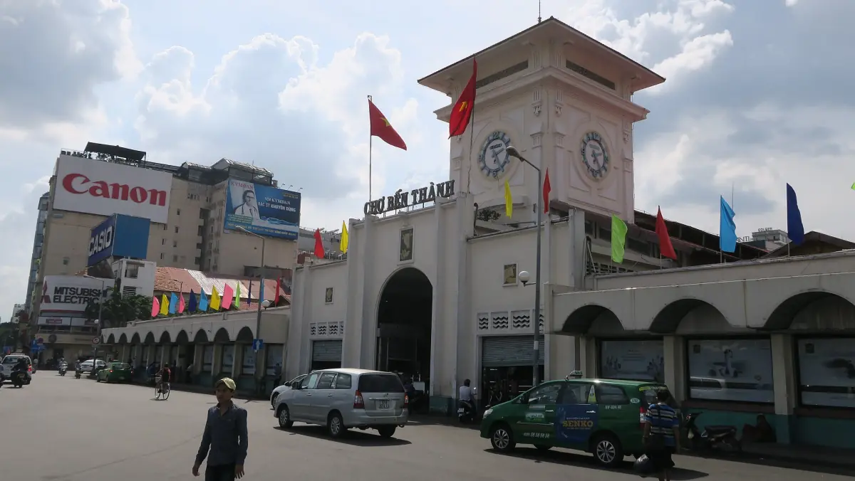 Eingang mit Uhrturm des Ben-Thanh-Markts mit Fahnen darüber
