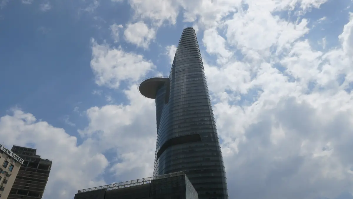 The Bitexco Financial Tower rising against a blue sky with white clouds
