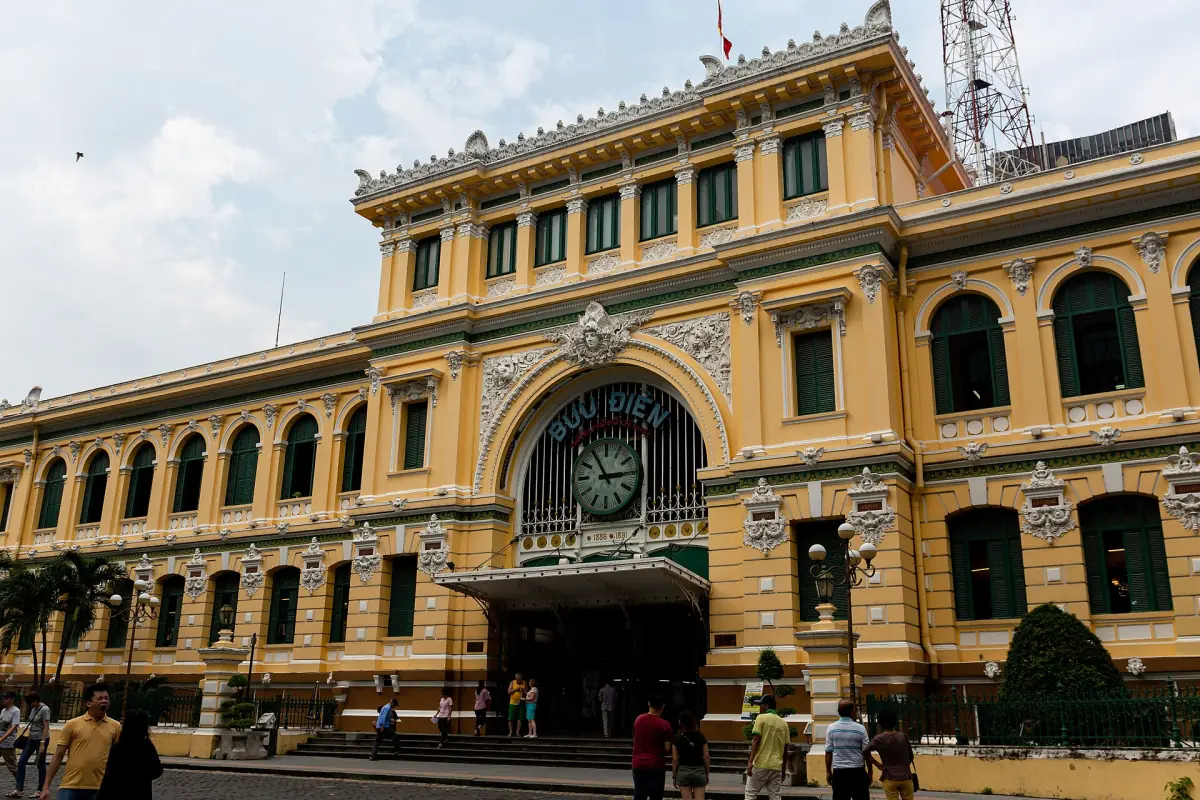 Yellow colonial facade of the Saigon Central Post Office in daylight