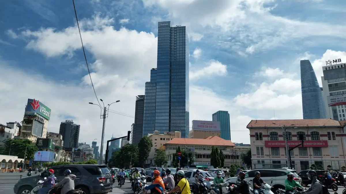 Con đường đông đúc với các tòa nhà cao tầng dưới trời xanh và mây