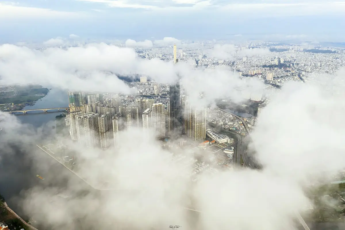 Low clouds drifting over the city and river in an aerial view